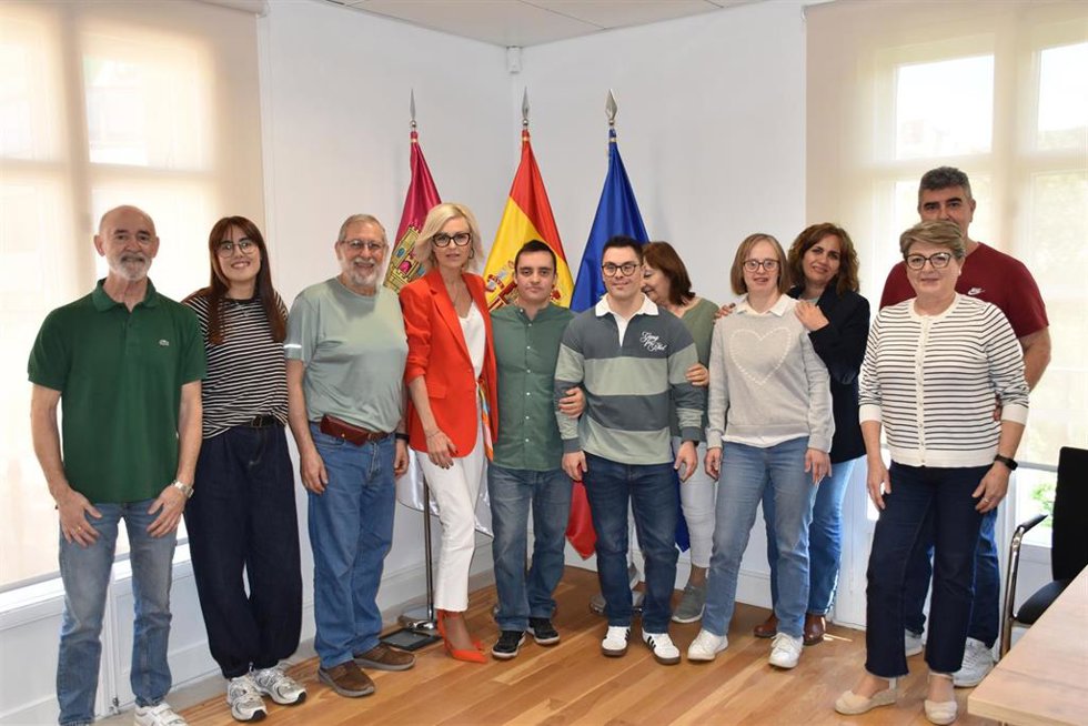 La delegada de la Junta, Marian López, recibe a los dos miembros de ADOCU, junto a sus familiares y representantes de la asociación.