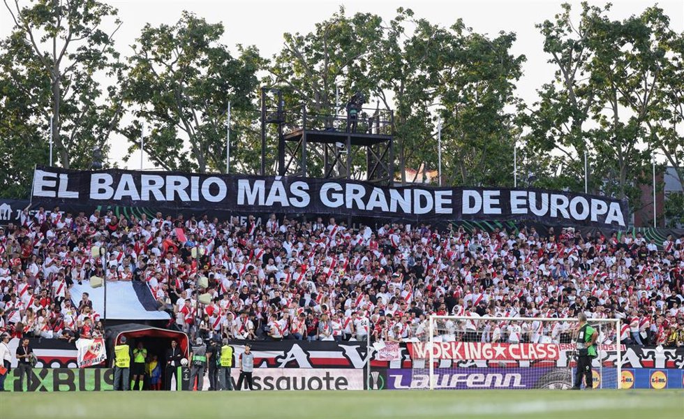 Pancarta con el texto 'El barrio más grande Europa' en el Estadio de Vallecas en la Conference League 2025/26.
