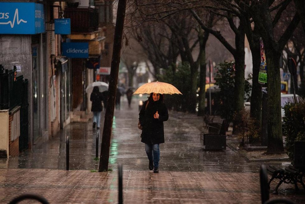 Archivo - Una persona se protege de la lluvia con paraguas