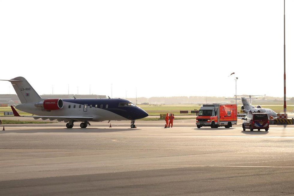 06 May 2026, Netherlands, Amsterdam: Medical staff in protective suits wait next to a German ambulance to receive the patients who have been evacuated from the hantavirus-hit cruise ship MV Hondius, after their arrival at Schiphol Airport in Amsterdam. Ph