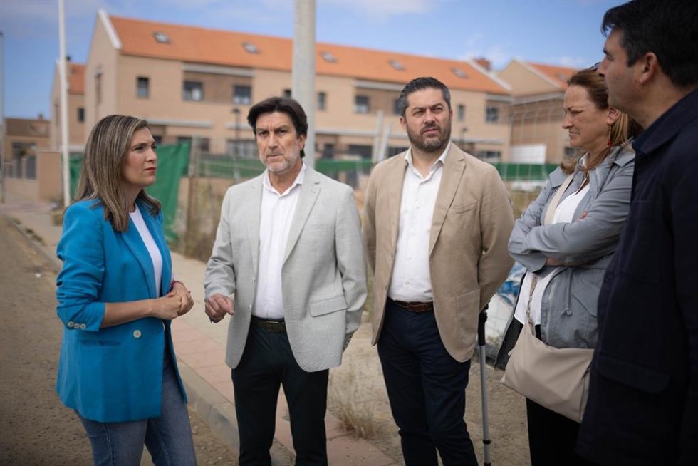 La viceportavoz del PSOE-A y candidata número uno por la provincia al Parlamento andaluz, María Márquez, junto a miembros del PSOE junto a unas viviendas en construcción.