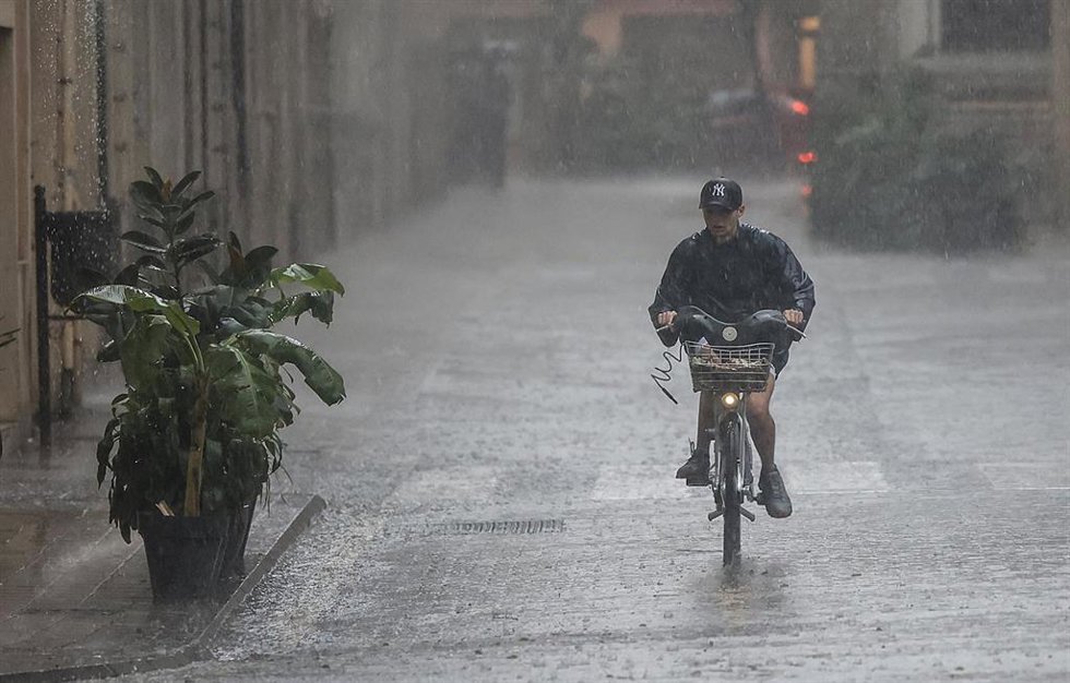 Archivo - Una persona en bicicleta bajo la lluvia, en imagen de archivo. 