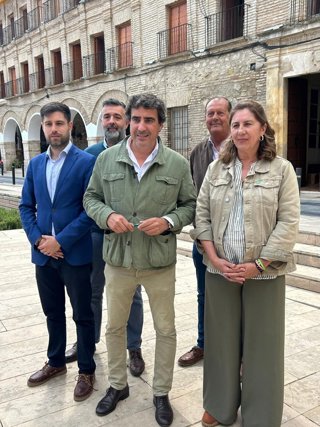 El candidato número dos de Vox por Córdoba al Parlamento de Andalucía, Juan José Coca (centro), en su visita a Baena.