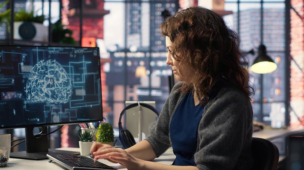 Female system admin doing maintenance on AI brain pc systems, sitting at office desk.