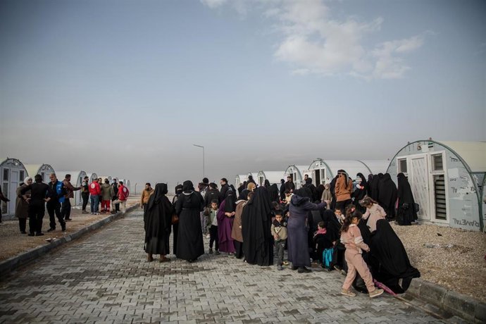 Archivo - Las mujeres esperan tras el traslado de cientos de personas desde el campo de Al Hol, en la al noreste de Siria. Decenas de miles de personas permanecieron recluidas durante años en el campo muchas de ellas acusadas de pertenecer al ISIS