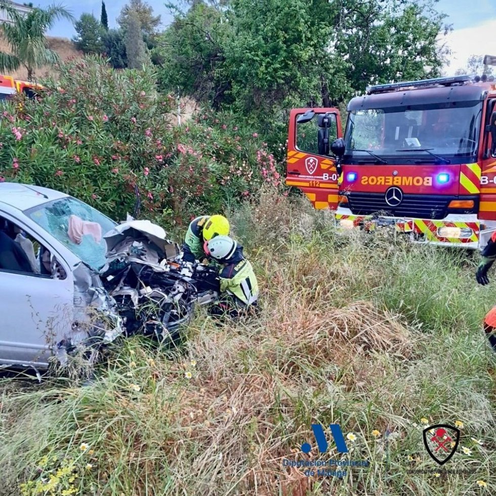 Imagen del rescate de una persona atrapada en el interior de un turismo en Torremolinos (Málaga).