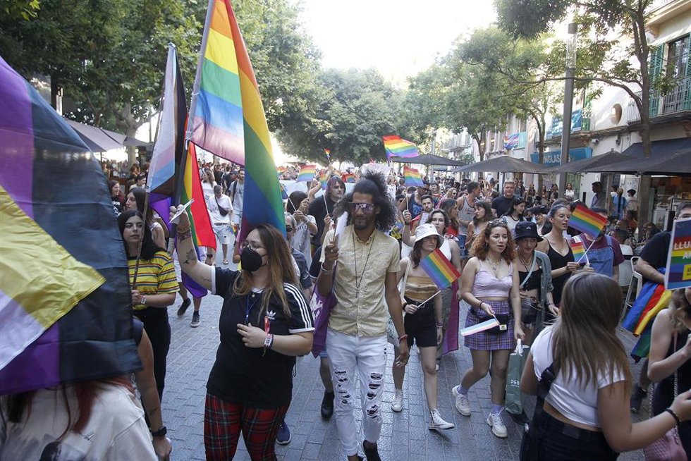 Archivo - Un grupo de personas con banderines durante una manifestación por el Orgullo LGTBI en Palma.