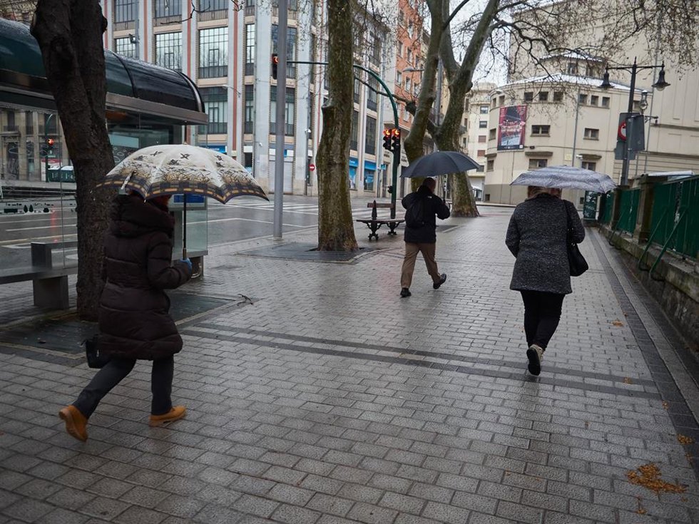 Archivo - Varias personas se protegen de la lluvia con sus paraguas.
