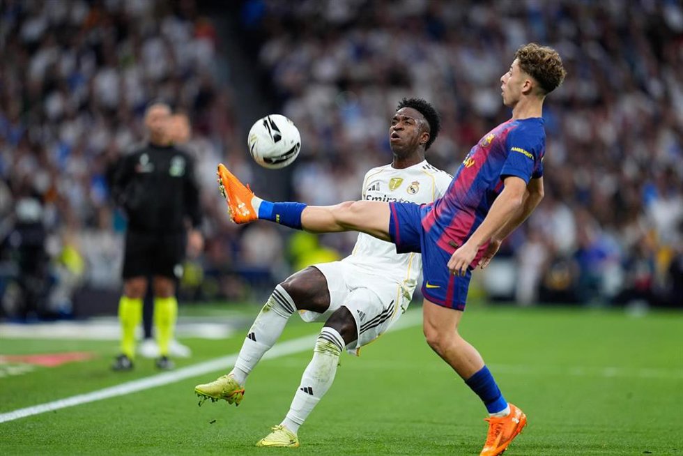 Archivo - Vinícius Júnior, del Real Madrid CF, y Fermín López, del FC Barcelona, disputan un balón durante el Clásico de LaLiga EA Sports disputado en el Santiago Bernabéu el 26 de octubre de 2025 en Madrid