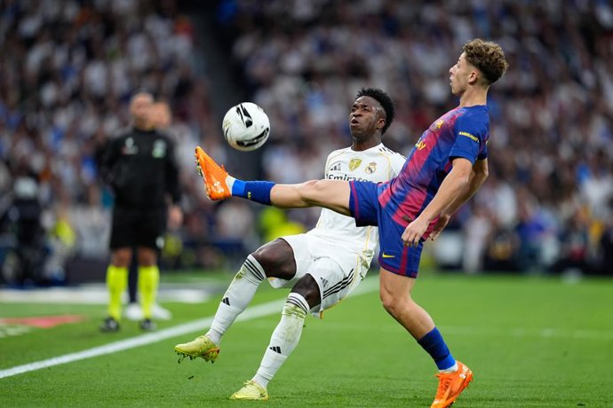 Archivo - Vinicius Junior of Real Madrid CF and Fermin Lopez of FC Barcelona compete for the ball during the Spanish League, LaLiga EA Sports, football match played between Real Madrid C.F. and FC Barcelona at Santiago Bernabeu stadium on October 26, 2025