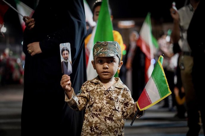 May 6, 2026, Iran, Iran: An Iranian boy wearing a fake military uniform holds a picture of Iran's newly appointed Supreme Leader, Ayatollah Mojtaba Khamenei, and the national flag during a state-organized rally, amid a ceasefire in the conflict involving 