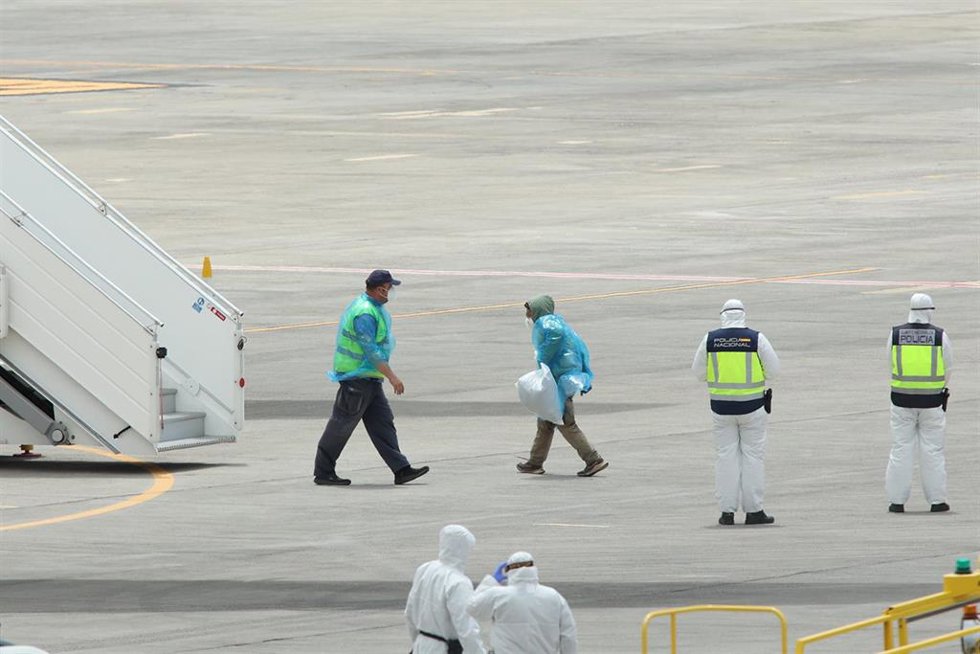 Policías nacionales y operarios vestidos con monos EPI y mascarillas coordinan a los viajeros evacuados del crucero MV Hondius, en el aeropuerto de Tenerife Sur, a 10 de mayo de 2026, en Tenerife, Islas Canarias (España). 