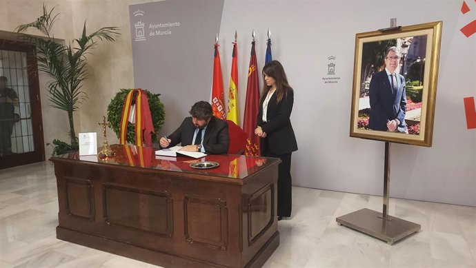 El presidente de la Región de Murcia, Fernando López Miras, escribe en el libro de condolencias habilitado por el Ayuntamiento en memoria del alcalde, José Ballesta, acompañado por la vicealcaldesa, Rebeca Pérez