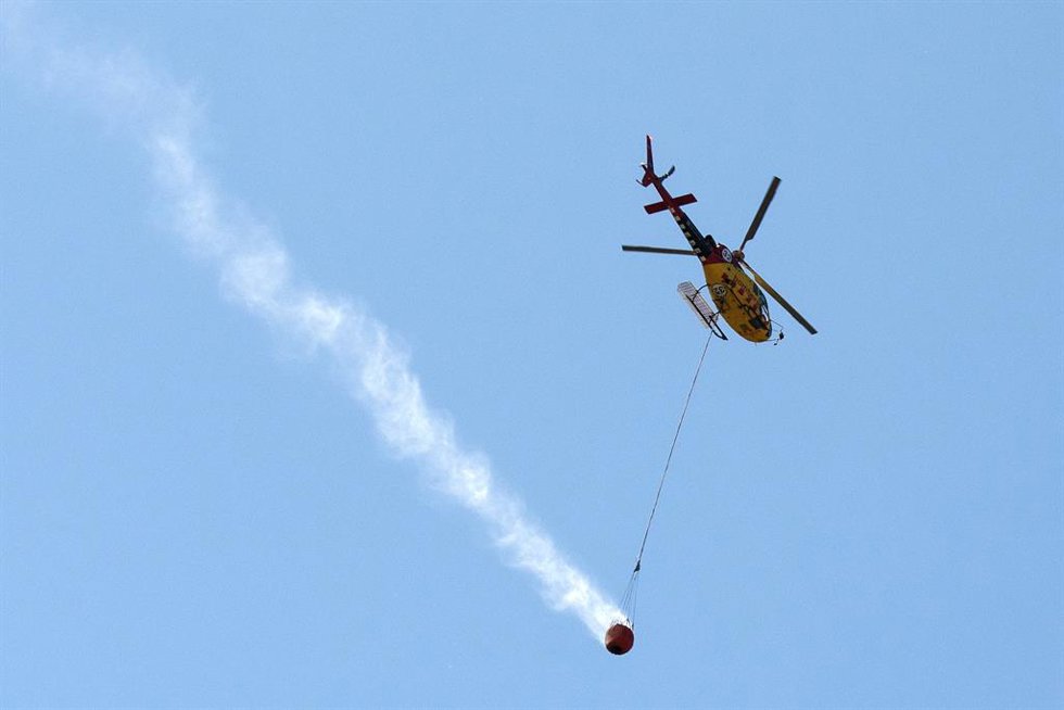 Archivo - Un helicóptero trabaja en las labores de exinción de un incendio forestal