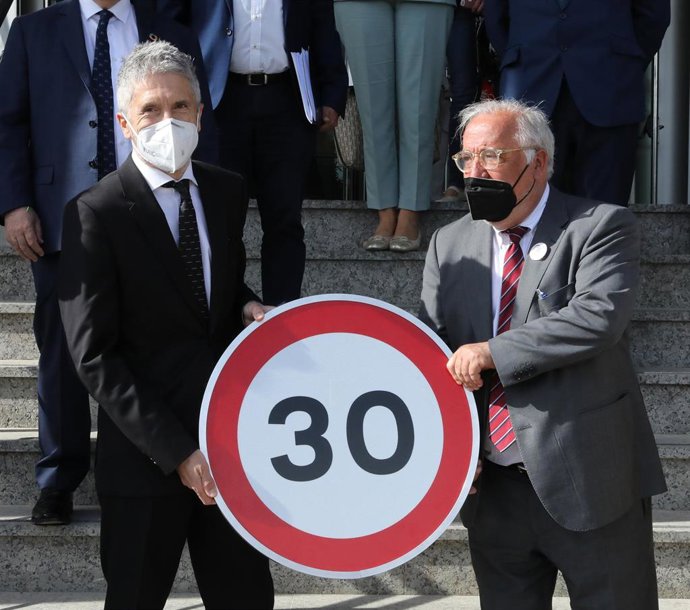 Archivo - El ministro del Interior, Fernando Grande-Marlaska (i) y el director general de Tráfico, Pere Navarro (d) posan con una señal durante la inauguración de la Jornada de la Dirección General de Tráfico (DGT) sobre la implantación de los 30 km/h en 
