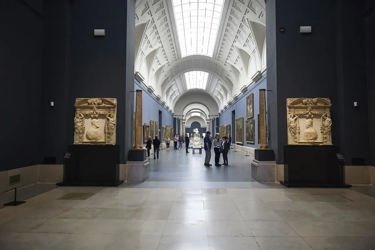 Varias personas observan cuadros en el Museo Nacional del Prado.