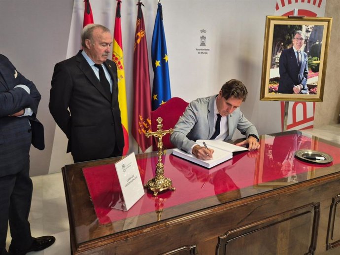 El presidente del Tribunal Superior de Justicia de la Región de Murcia, Manuel Luna Carbonell, firmando en el libro de condolencias por el fallecimiento del alcalde José Ballesta