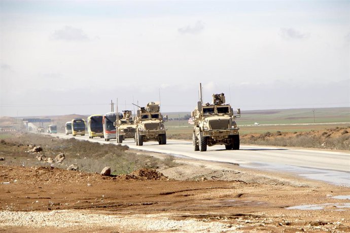 Archivo - Vehículos militares estadounidenses escoltan autobuses de pasajeros que transportan detenidos de Estado Islámico desde el noreste de Siria a Irak