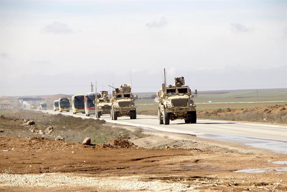 Archivo - Vehículos militares estadounidenses escoltan autobuses de pasajeros que transportan detenidos de Estado Islámico desde el noreste de Siria a Irak