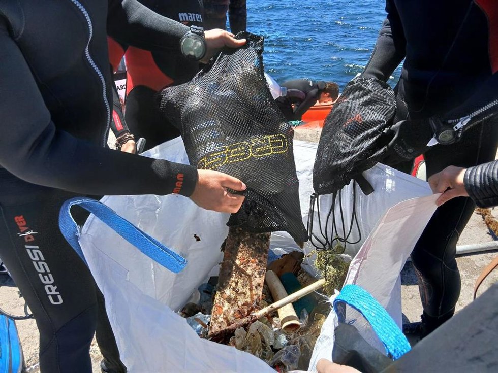 Buceadores voluntarios reúnen residuos extraídos durante la jornada de limpieza de fondos marinos en Cabo de Gata-Níjar (Almería).