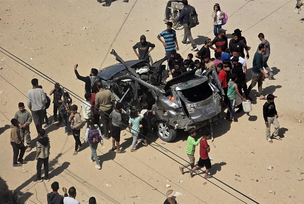 Palestinos junto a un vehículo bombardeado por el Ejército de Israel en la Franja de Gaza (archivo)