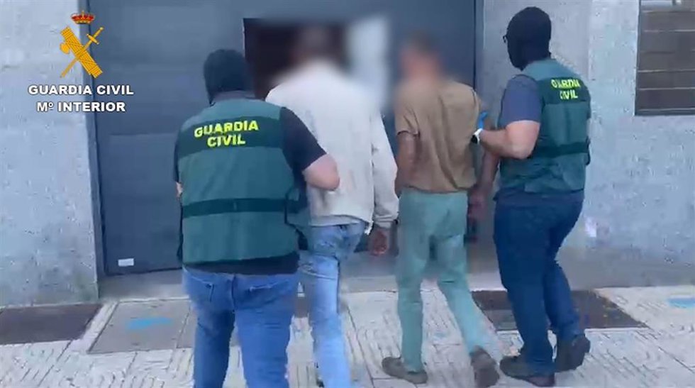 Agentes de la Guardia Civil con dos de los detenidos en la operación desarrollada en Roquetas de Mar (Almería).