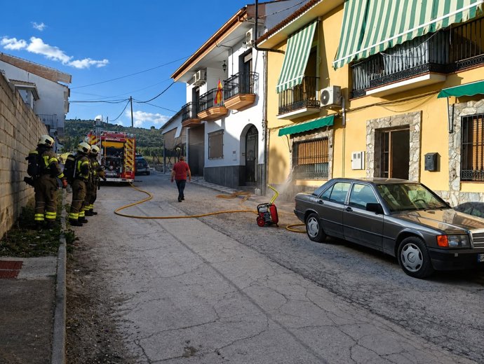 Bomberos actúan en la vivienda de Pinos Puente que sufrió el incendio.