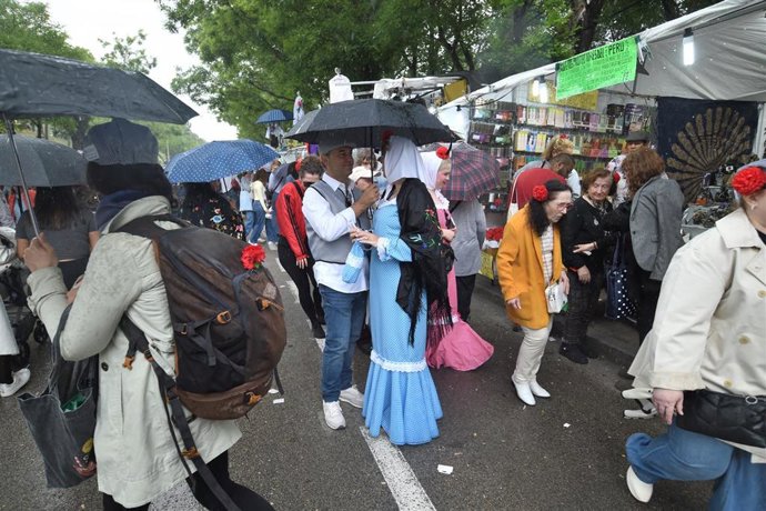 Archivo - Varias personas se protegen de la lluvia en la pradera de San Isidro