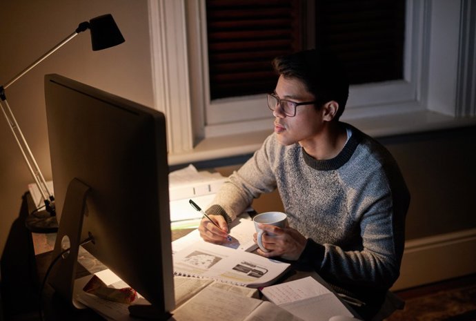 Archivo - Joven trabajando de noche.