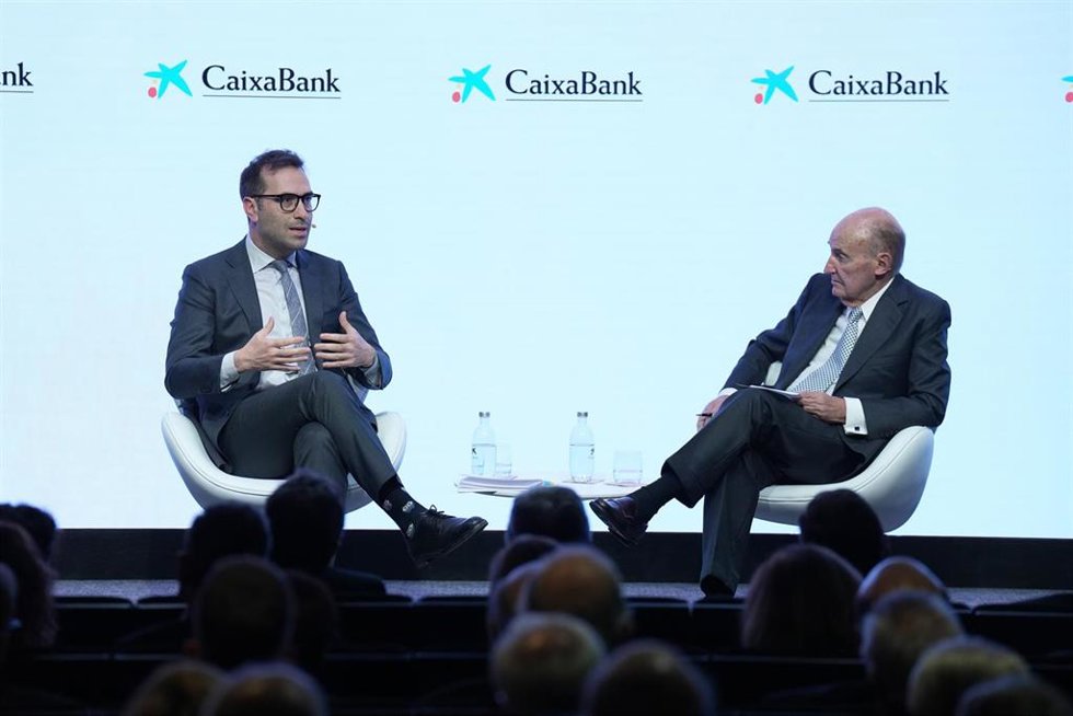 El vicepresidente primero del Gobierno y ministro de Economía, Carlos Cuerpo (i), y el presidente de la Societat Econòmica Barcelonesa d'Amics del País, Miquel Roca (d) durante la conferencia ‘Presente y futuro de la economía española’