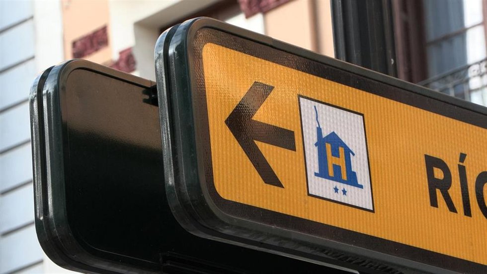 Archivo - Señal en una calle que dirige a un hotel.