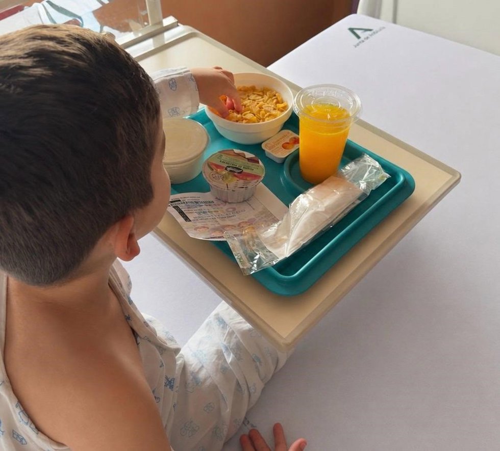 Un menor hospitalizado ante el desayuno especial preparado en el Hospital de Valme por el Día del Niño Hospitalizado.