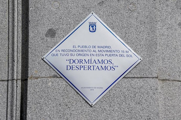 Archivo - Placa con uno de los lemas ya clásicos del 15M, 'Dormíamos, despertamos', que luce en el número 10 de la Puerta del Sol desde hace dos años y medio, a 12 de mayo de 2021, en Madrid (España). La placa se encuentra a metros del punto donde estuvo 