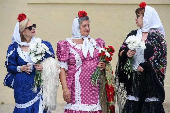 Archivo - Varias mujeres vestidas de chulapas reparten claveles rojos y blancos en Las Vistillas, a 13 de mayo de 2023, en Madrid (España). Foto de archivo