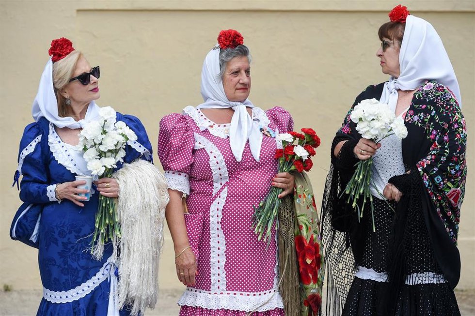 Archivo - Varias mujeres vestidas de chulapas reparten claveles rojos y blancos en Las Vistillas, a 13 de mayo de 2023, en Madrid (España). Foto de archivo