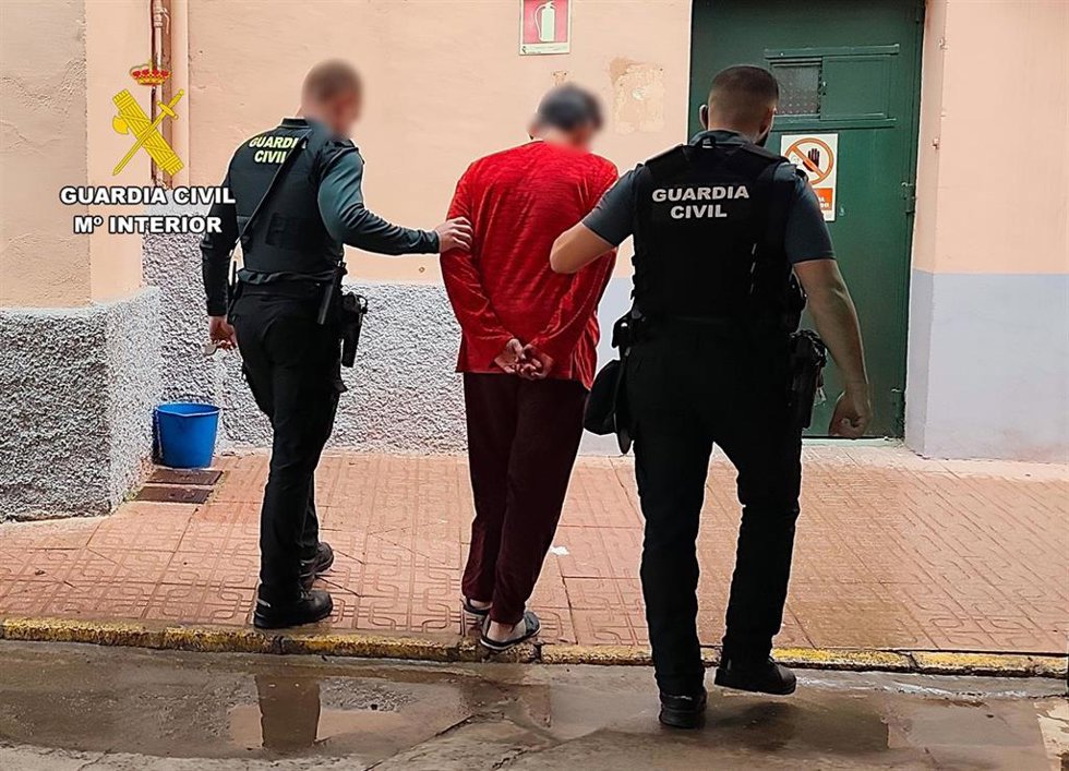 El detenido es custodiado por dos agentes de la Guardia Civil