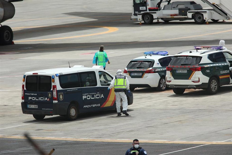 Policías nacionales, guardias civiles y militares de la UME vestidos con monos EPI y mascarillas coordinan a los viajeros evacuados del crucero MV Hondius, en el aeropuerto de Tenerife Sur, a 10 de mayo de 2026, en Tenerife, Islas Canarias (España). 