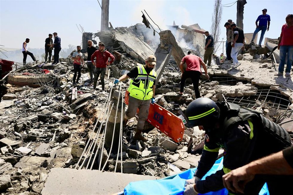 Equipos de rescate buscan víctimas entre los escombros de un edificio tras ataques de Israel en Saksakiyé, sur de Líbano