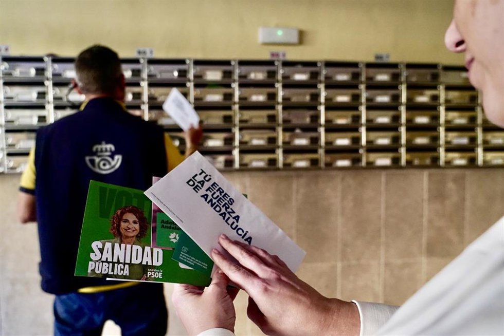 Un funcionario de Correos reparte las papeletas electorales en los buzones.