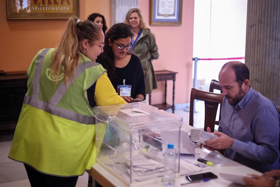 Archivo - Una integrante de Correos llega a la mesa electoral para entregar los votos ejercido por este método en Sevilla, en una imagen de archivo