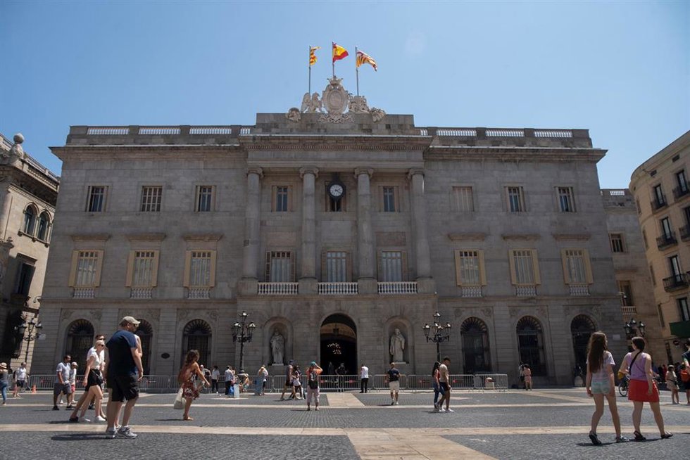 Archivo - Varias personas caminan delante del edificio del Ayuntamiento de Barcelona, en una imagen de archivo