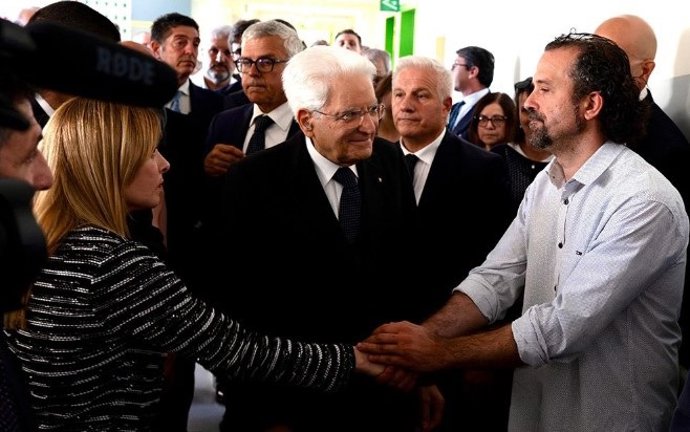 A primeira-ministra da Itália, Giorgia Meloni, e o presidente da Itália, Sergio Mattarella (no centro da imagem), cumprimentam o civil Luca Signorelli
