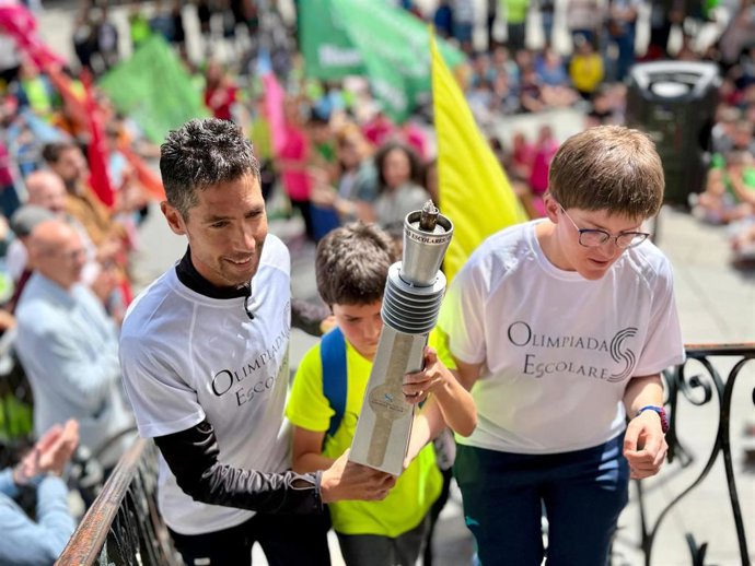 Un alumno del Carlos del Lecea porta la antorcha olímpica con los padrinos de la Olimpiada, Celia Mesonero y Javi Guerra.