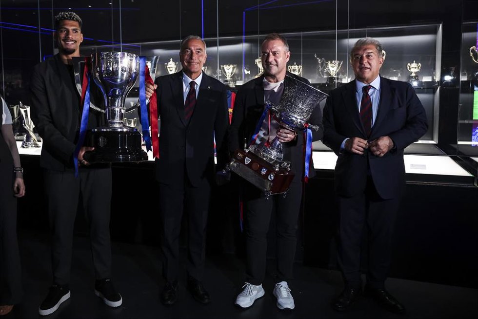 Ronald Araújo, Hansi Flick, Joan Laporta y Rafa Yuste durante la ceremonia de presentación de los trofeos de LaLiga EA Sports y la Supercopa de España del FC Barcelona, celebrada en el museo del club en Barcelona