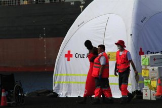 Archivo - Miembros de Cruz Roja atienden a migrantes llegados en patera a Tenerife.