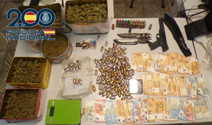 En la entrada y registro de la vivienda se localizaron 1.510 gramos de hachís, 1.180 gramos de cogollos de marihuana, 9.765 euros, dos puñales, un machete, 25 cartuchos de escopeta, una pistola de air soft y dos balanzas de precisión.