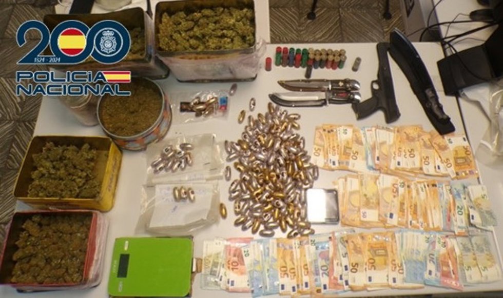 En la entrada y registro de la vivienda se localizaron 1.510 gramos de hachís, 1.180 gramos de cogollos de marihuana, 9.765 euros, dos puñales, un machete, 25 cartuchos de escopeta, una pistola de air soft y dos balanzas de precisión.