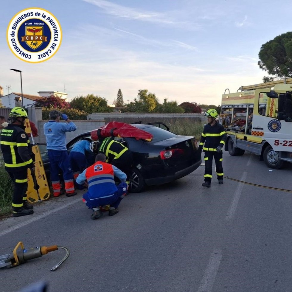 Efectivos de bomberos y sanitarios atendiendo a las personas implicadas en el accidente de la carretera del Pradillo en Conil.