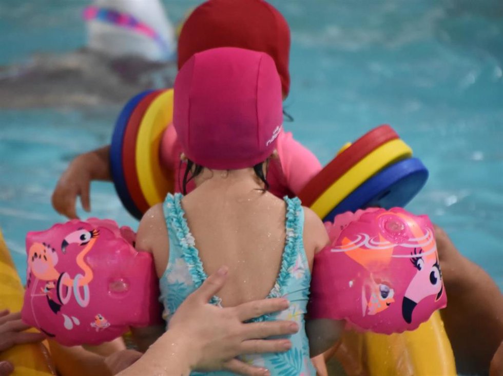 Varias niñas nadan en una piscina.