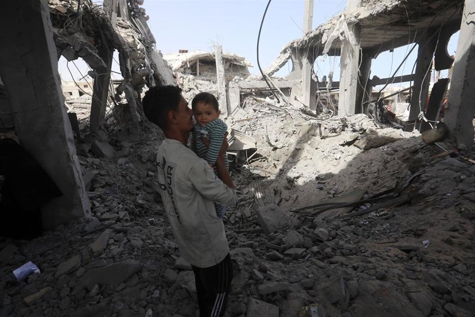 Palestinos entre edificios bombardeos por Israel en Yabalia, en el norte de la Franja de Gaza